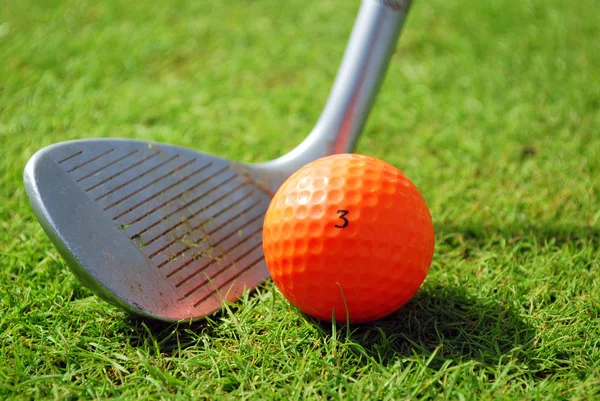Golf-clube e bola de golfe laranja — Fotografia de Stock