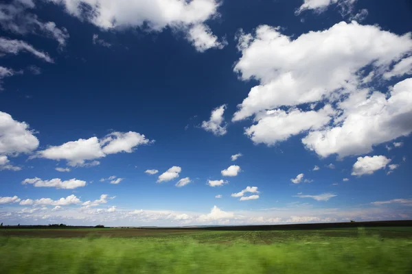 Campo verde e nuvens — Fotografia de Stock