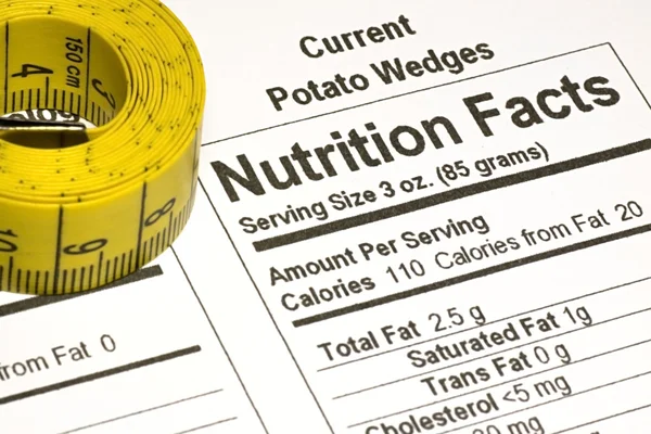 Fita métrica ao lado de fatos nutricionais — Fotografia de Stock