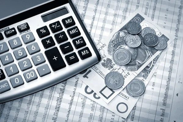 Калькулятор, польские деньги и газета — стоковое фото