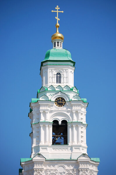 Bell tower of cathedral with a big clock in Russia