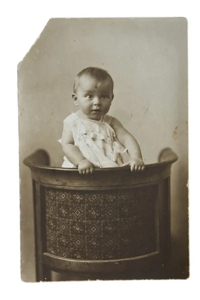 Das kleine Mädchen auf einem Stuhl — Stockfoto