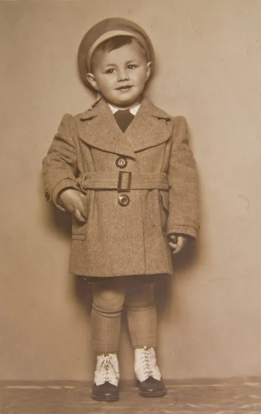 Um rapazinho de casaco, uma foto antiga — Fotografia de Stock