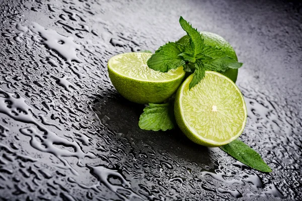 Zielone limonki z miętą i woda spada — Zdjęcie stockowe