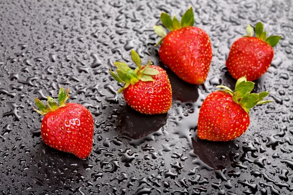 stock image Strawberries on wet black background