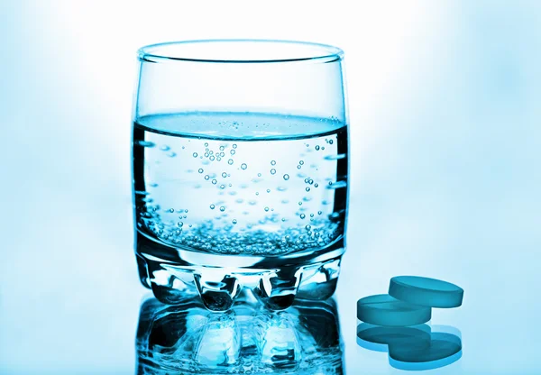 Et glass vann og piller – stockfoto