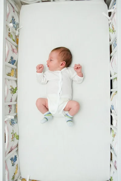Новорожденный мальчик спит в большой кровати — стоковое фото