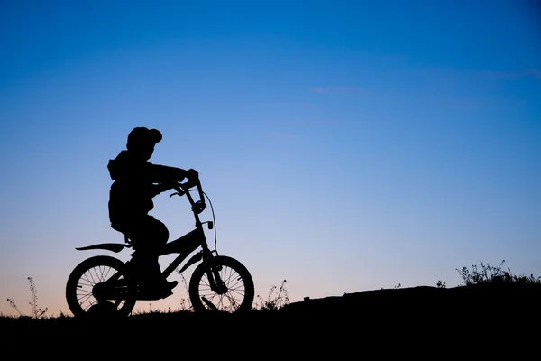 Silhouet van jongen op fiets — Stockfoto