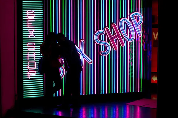 Fiatal pár szex shop ellen Silhouette Stock Kép