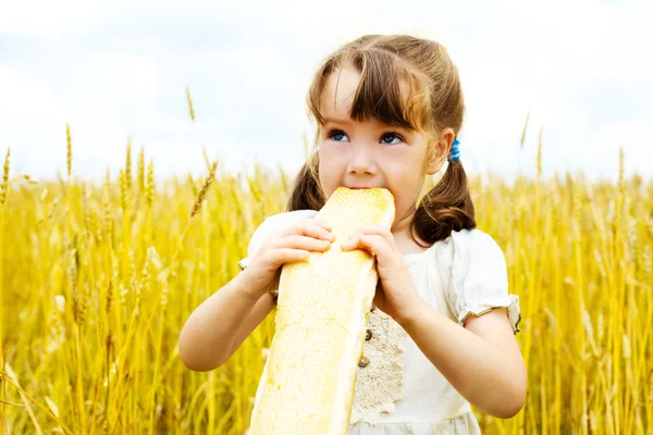 Girl eating a long loaf — Stock Photo, Image