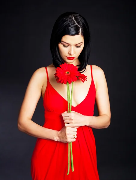 Nachdenkliche Frau mit einer Blume — Stockfoto