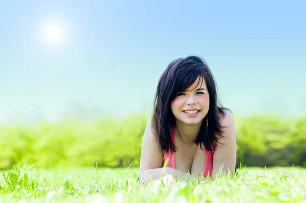 Молодая счастливая девушка лежит на траве — стоковое фото