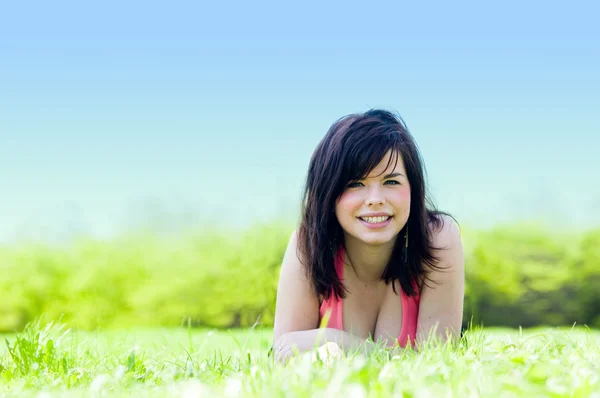 Young happy girl lying on grass — Stock Photo, Image