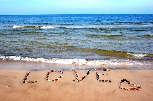 Слово ЛЮБОВЬ на пляже песок — стоковое фото