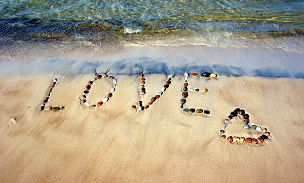 Ordet kärlek på sandstrand — Stockfoto