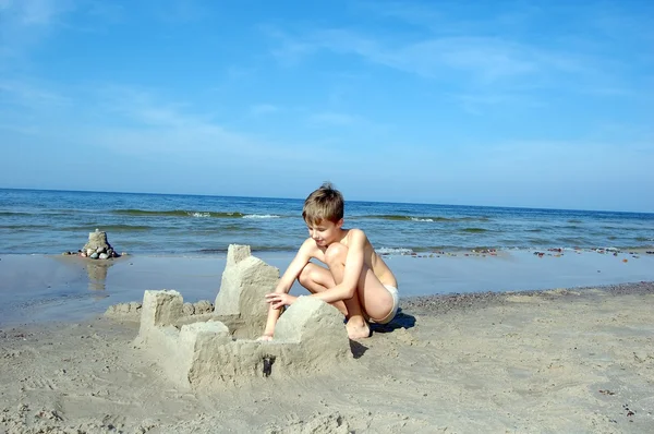 Jongen spelen op het strand — Stockfoto