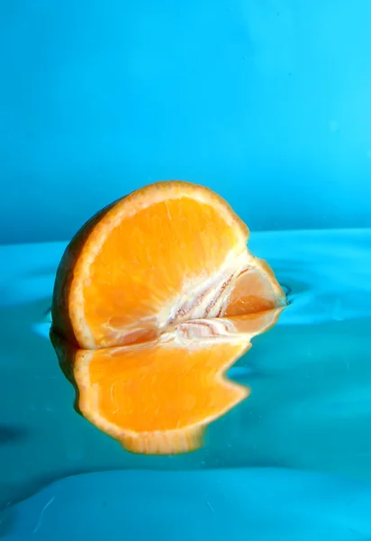 Свежий апельсин плавает в воде — стоковое фото