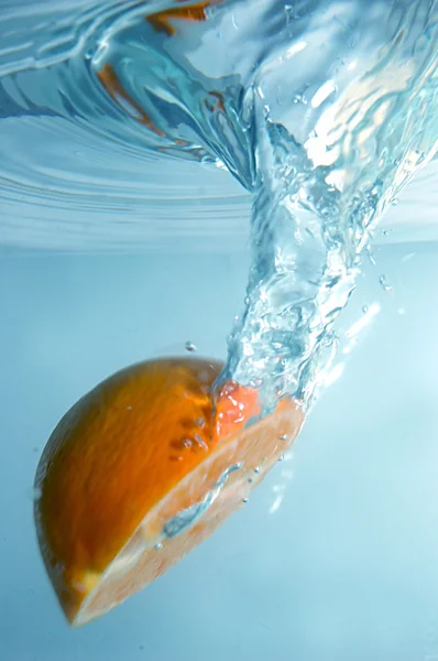 Fresh orange into blue, clear water — Stock Photo, Image