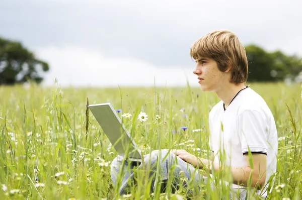 Chłopiec z notebooka na polu — Zdjęcie stockowe