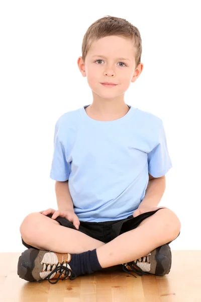 Chłopiec siedzi na białym tle — Zdjęcie stockowe