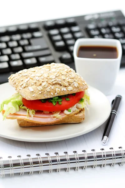 stock image quick lunch in the office - bun and cup of coffee