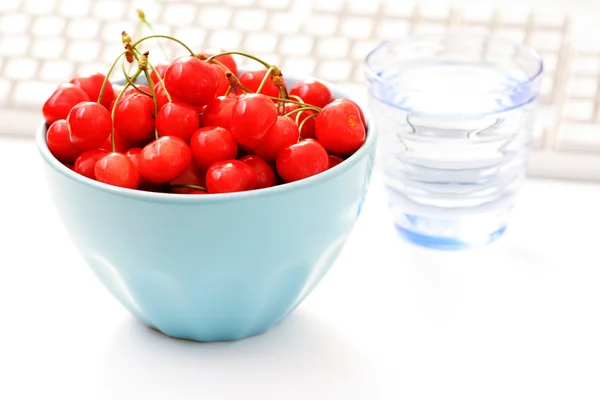 stock image healthy snack in the office - bowl of cherries