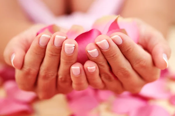 花びらのローズ 美容治療の女性の手 — ストック写真