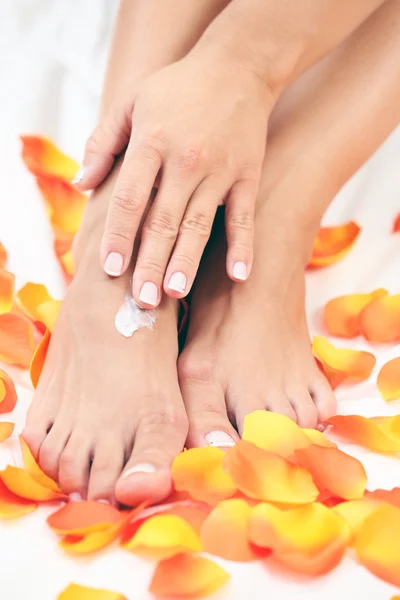 女性の手と足の花びらとローズ 美容トリートメント — ストック写真