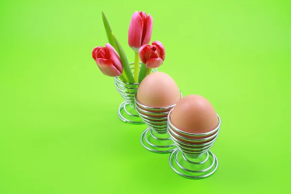 三个鸡蛋和孤立的绿色粉红郁金香 — 图库照片