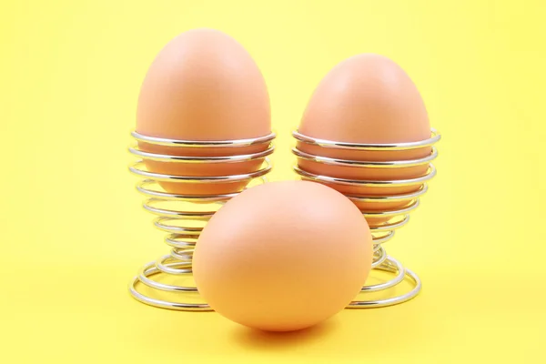在黄色背景上的三个鸡蛋的特写镜头 — 图库照片