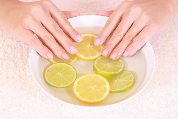 stock image bowl of pure water with citrus fruits - hands care