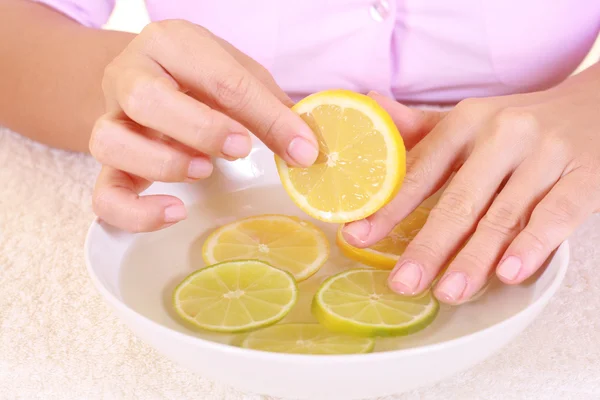 stock image bowl of pure water with citrus fruits - hands care