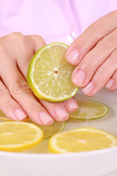 stock image bowl of pure water with citrus fruits - hands care