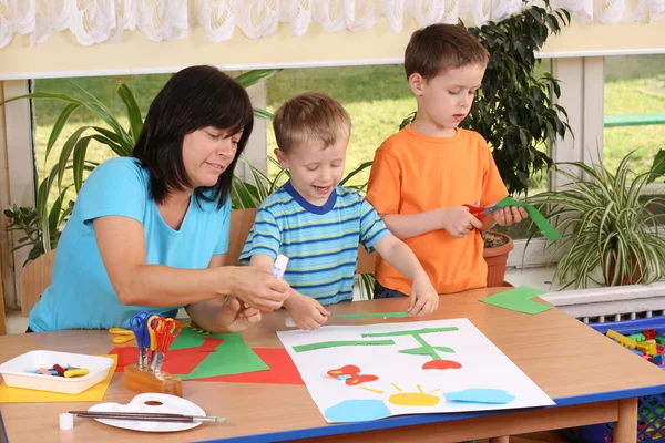 stock image Teacher and two preschoolers making some decoration