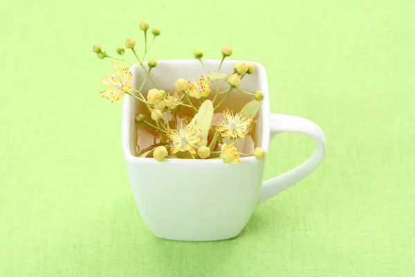 Φλιτζάνι Τσάι Και Linden Λουλούδια Στο Πράσινο — Φωτογραφία Αρχείου