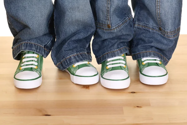 四个孩子双腿在地板上的运动鞋 — 图库照片