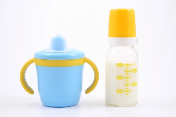 Bottle of milk and baby cup — Stock Photo, Image