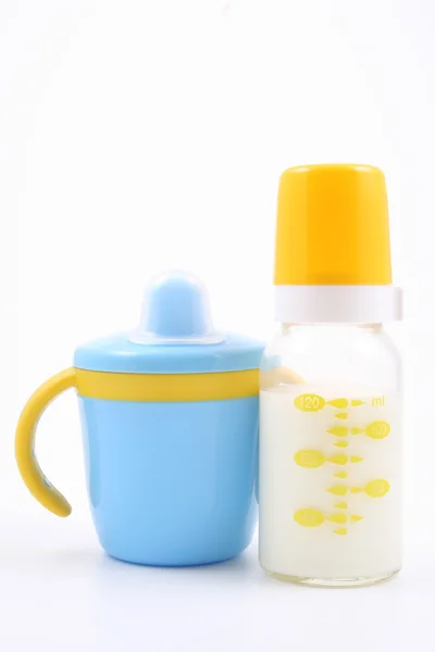 Bottle of milk and baby cup — Stock Photo, Image