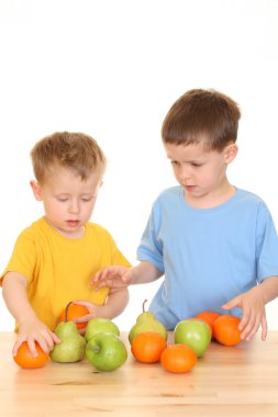 five and three years old boys playing with fruits isolated on white clipart