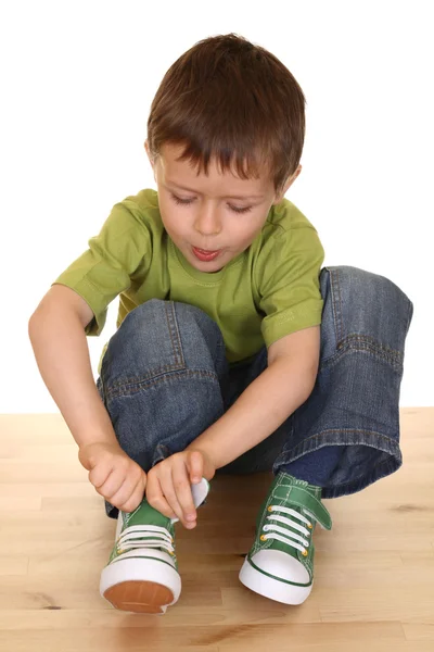 Niño Cinco Años Trata Ponerse Sus Zapatillas Aisladas Blanco — Foto de Stock