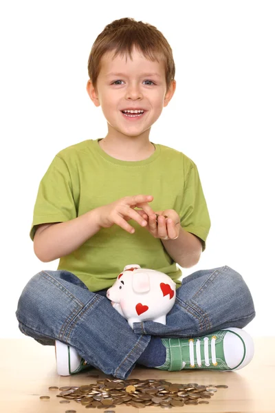 stock image five years boy with piggy bank and money isolated on white