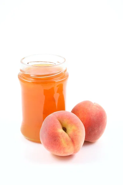 桃のジャムの瓶と白で隔離されるいくつかの新鮮な果物 — ストック写真