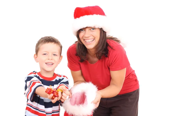 白で隔離されるクリスマスの帽子で楽しんでいる母親と 年の古い息子 — ストック写真