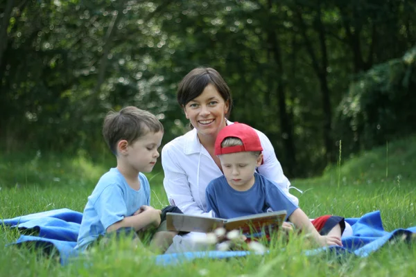Mutter Und Zwei Söhne Lesen Draußen Buch — Stockfoto