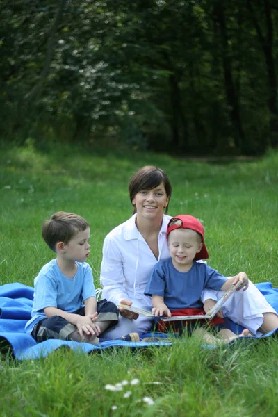 Мати Два Сини Читають Книгу Надворі — стокове фото