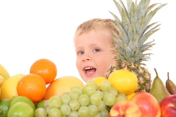 岁的男孩和大量的白色上孤立的各种水果 — 图库照片