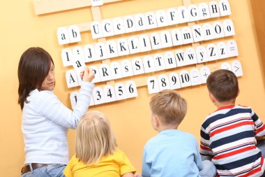 teacher and three preschoolers during lesson clipart