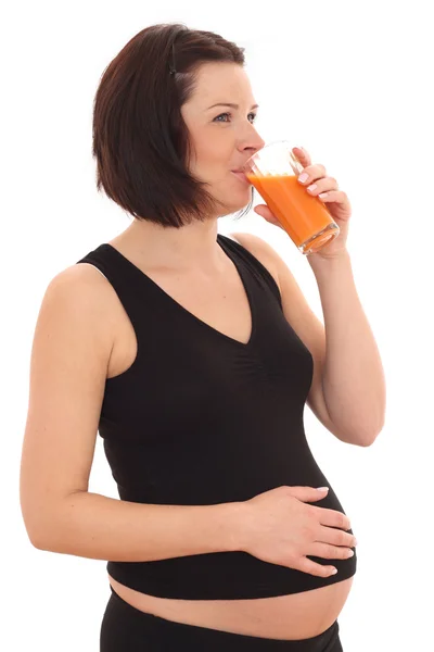 年轻美丽的孕妇与玻璃的胡萝卜汁白隔离 — 图库照片