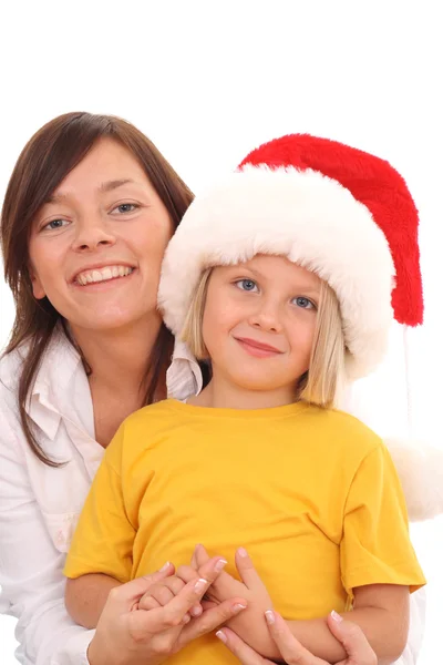 白で隔離されるクリスマス帽子で楽しんでいる母親と 年の古い女の子 — ストック写真
