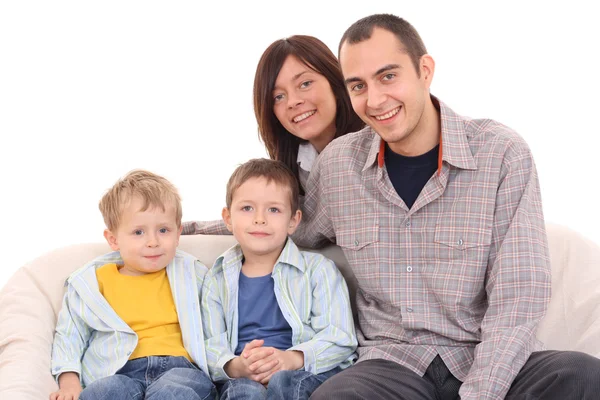母亲父亲和两个儿子在沙发上 幸福家庭 图库图片